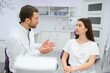 © Serhii - people, medicine, stomatology and health care concept - woman patient talking to male dentist and complain of toothache at dental clinic office.