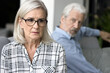 © fizkes - Stressed desperate mature wife feeling frightened with annoyed older husband behind, facing abuse, domestic violence. Senior couple getting relationship crisis, marriage problems