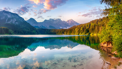  Impressive summer sunrise on Eibsee Lake with Zugspitze mountain range. The sunny outdoor scene in German Alps, Bavaria, Germany, Europe. The beauty of nature concept background.