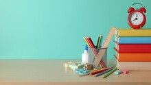 School Background. School Supplies, A Book Stack, And An Alarm Clock Are On The Desk.