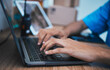 © Tamline/peopleimages.com - Hands, laptop and surveillance with a security guard in a CCTV room closeup to monitor criminal activity. Computer, safety and typing with an officer searching for evidence or information online
