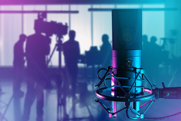 Wall Mural - Microphone for sound recording. Film crew silhouette. Condenser microphone. Broadcast equipment. Microphone near operator with camera. TV and radio equipment. Micro for radio podcasts