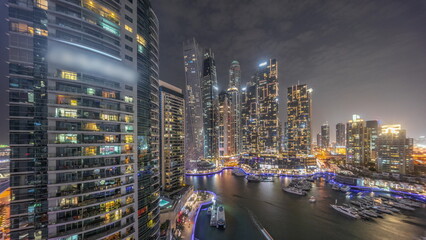 Wall Mural - Dubai marina tallest skyscrapers and yachts in harbor aerial day to night timelapse.