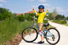 Little Kid Boy Ride A Bike In The Park. Kid Cycling On Bicycle. Happy Smiling Child In Helmet Riding A Bike. Boy Start To Ride A Bicycle. Sporty Kid Bike Riding On Bikeway. Kids Bike.