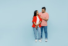 Full Body Happy Fun Young Couple Two Friends Family Indian Man Woman Wear Red Casual Clothes T-shirts Together Look To Each Other Hug Cuddle Isolated On Pastel Plain Light Blue Cyan Color Background.
