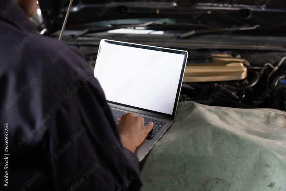 back view mechanic using laptop computer with white screen for checking ...