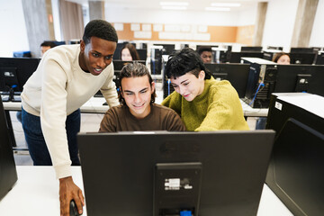 Multiracial students using personal computer at IT college class - Back to school and campus lifestyle concept - Main focus on center male face