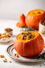 Poster - Tasty baked pumpkin stuffed with rice, vegetables, cashews and dried fruits on white background