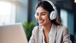 © EmmaStock - Indian ethnic female manager wearing wireless headphones looking at laptop