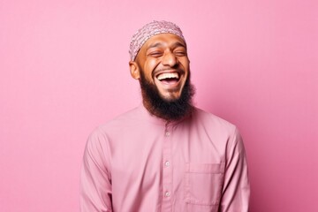 Wall Mural - Portrait of a happy african american man laughing isolated over pink background