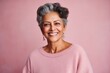 © Leon Waltz - Group portrait of an Indian woman in her 50s against a pastel or soft colors background wearing a cozy sweater