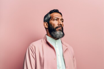 Canvas Print - portrait of mature indian man in pink jacket looking away isolated on pink