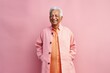 © Leon Waltz - Portrait of a happy senior asian man in pink coat standing against pink background