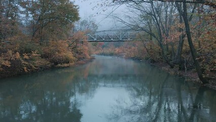 Wall Mural - Vintage old-fashioned steel bridge over autumn green river with foggy in mountain country scenic location 
