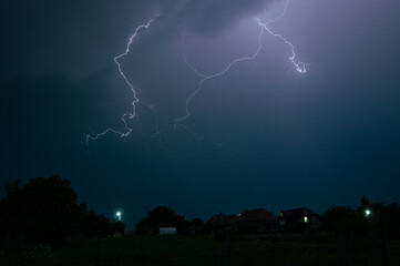 Wall Mural - lightning discharge high in the sky during a severe nighttime thunderstorm