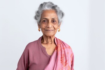 Lifestyle portrait of an Indian woman in her 70s against a white background