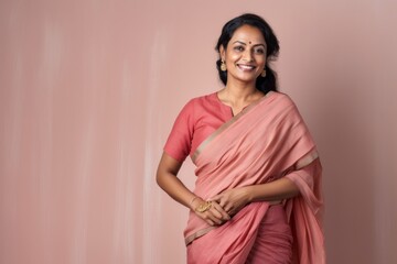 Medium shot portrait of an Indian woman in her 40s wearing traditional sari in a minimalist background