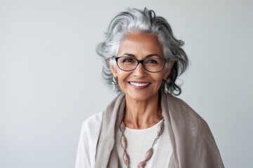 Wall Mural - Lifestyle portrait of an Indian woman in her 60s in a minimalist background