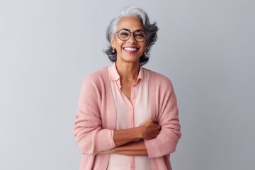 Wall Mural - Lifestyle portrait of an Indian woman in her 60s in a minimalist background