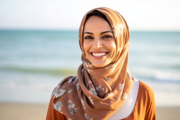 Wall Mural - Lifestyle portrait of an Indian woman in her 30s wearing hijab in a beach 