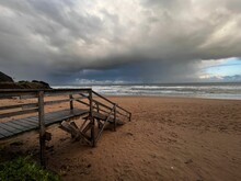 Peaceful Scene Of An Empty Boardwalk Along The Shoreline Of A Tranquil Ocean