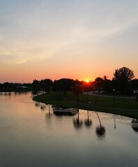 Canvas Print - Aerial of a small calm lake with the bright golden sunset in the background