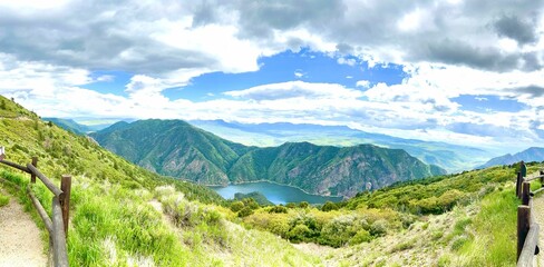 Sticker - Wooden fence in a picturesque landscape overlooking a mountain lake and grassy mountain range