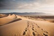 © Usman - Photo of footprints in the desert sand with majestic mountains in the backdrop