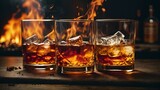 Fototapeta Do akwarium - Photo of three glasses of whiskey with a fiery backdrop
