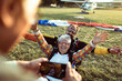 © Marko Geber - Senior man taking a picture of his wife after landing from a skydive with her instructor