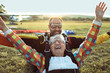© Marko Geber - Senior woman skydiving with her instructor and landing on a field with their parachutes