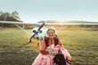 © Marko Geber - Portrait of a senior woman skydiver smiling and looking at camera with an airplane behind her on a field