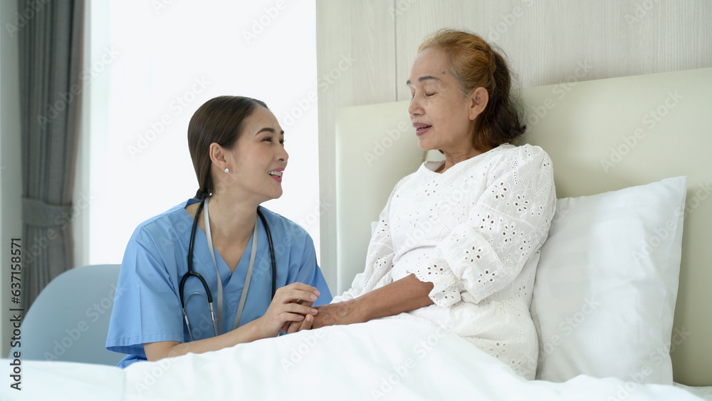 Take care senior lady patient on the bed talking to caring female nurse at home. Concept of wellness consultation, caregiver, elderly healthcare and homeopathic doctor.