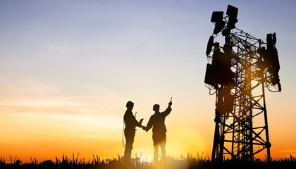 Silhouette architect electrician team in sunset Two engineers are planning to power towering outdoor telecommunication antenna tower that will improve the performance of generation 5G technology.