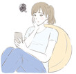© yuri nakashima - クッションにもたれて頬杖をついてスマホを見て悩む女性