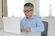 © sirisak piyatharo - Middle age business man working at home with laptop on desk
