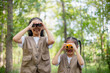 © FAMILY STOCK - Happy Little Asian girls looking ahead and smiling child with the binoculars in the park. Travel and adventure concept. Freedom, vacation
