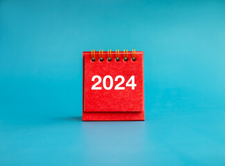 Poster - happy new year 2024 banner background. 2024 white numbers year on red small desk calendar cover stan