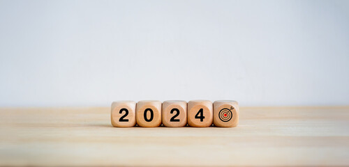 Poster - 2024 Happy New year background. 2024 year number and target icon on wooden cube blocks arranged on white banner background with copy space. Welcome, Merry Christmas. Business goal and success concept.