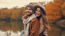 Lovely Couple Having Fun Together In Nature. Fashion Couple Enjoying Autumn. Boyfriend Carrying His Girlfriend On Piggyback.Young Couple Walking Near Lake In Autumn