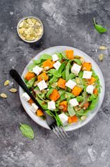 Wall Mural - Pumpkin Salad with Arugula, Feta Cheese, and Pumpkin Seeds, Salad Mix with Roasted Pumpkin, Autumn Salad