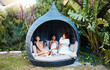 © Anela/peopleimages.com - Travel, luxury and happy women on vacation talking in a conversation or friends on an outdoor getaway together. Wine, laughing and people on holiday in nature bonding in happiness in a modern tent