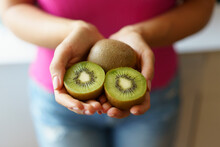 Hands Of Woman Holding Kiwi Fruits