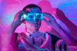 © Westend61 - Man wearing smart glasses in neon lights