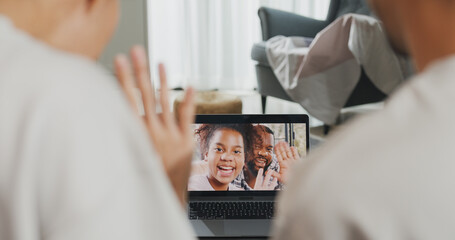 Sticker - Happy young Asian couple sit on couch smiling looking at laptop screen talk video call with friends at home on holiday. Smile young husband and wife webcam conversation using internet connection.