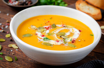 Wall Mural - Pumpkin Soup, Tasty Homemade Pumpkin, Sweet Potato, Carrot Soup in a Bowl on Dark Background