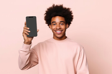 Happy African American teen student holding mobile cell phone pointing finger at smartphone mock up big screen template presenting application, using cellphone showing ad isolated on beige background.