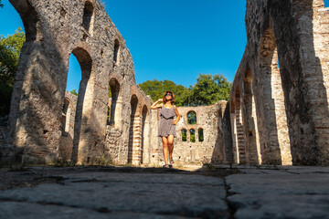 Wall Mural - Very happy female tourist walking in Great basilica in Butrint or Butrinto National Park, Albania