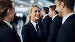 Smiling blonde female flight attendant talking to her colleagues