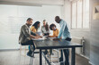 © Flamingo Images - Diverse businesspeople working together around a table in an office